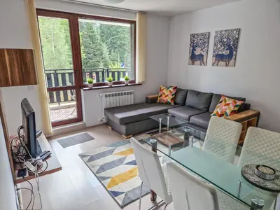 a living room with a couch and a table at Sunny Apartment C25 in Borovets