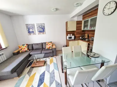 a living room with a couch and a glass table at Sunny Apartment C25 in Borovets