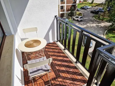 a balcony with a table and chairs on a balcony at Sunny Apartment C25 in Borovets