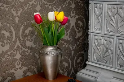 a vase with three flowers in it on a table at Agora Boutique Hotel in Sofia