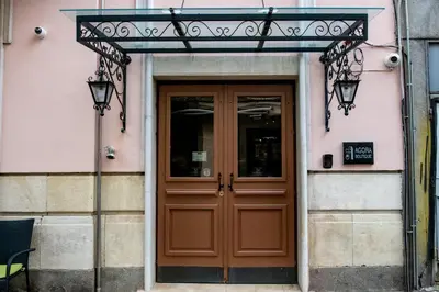 a wooden door on a pink building with a sign above it at Agora Boutique Hotel in Sofia