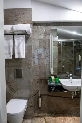 a bathroom with a sink and a toilet and a mirror at Agora Boutique Hotel in Sofia