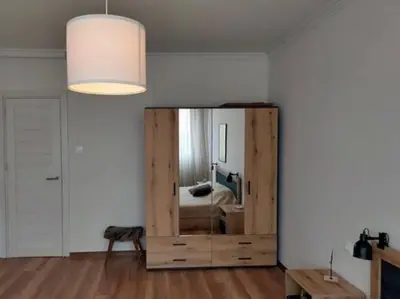 a bedroom with a large wooden cabinet with a mirror at Specious Modern Apartment in Sofia