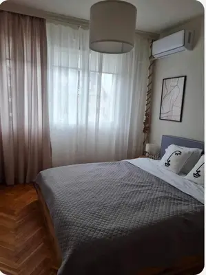 a bedroom with a bed and a large window at Specious Modern Apartment in Sofia