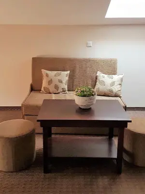 a living room with a couch and a coffee table at Hotel Podkovata in Etropole