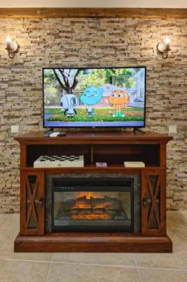 a living room with a television and a fireplace at Къща за гости Relax in Hisarya