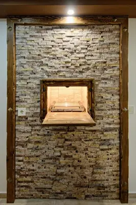 a brick wall with a fireplace in a room at Къща за гости Relax in Hisarya