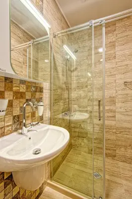 a bathroom with a sink and a glass shower at Къща за гости Relax in Hisarya
