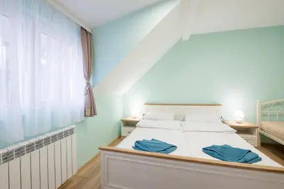 a bedroom with a bed with blue walls and a window at Serdika Old City House in Sofia