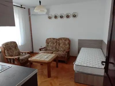 a living room with a bed and two chairs at Цвят бяло in Sofia