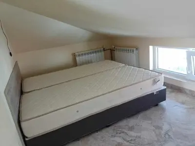 a large bed in a room with a window at Цвят бяло in Sofia