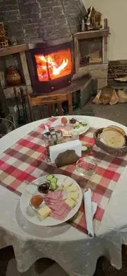 a table with plates of food on a table with a fireplace at Guest House Popov in Marchevo