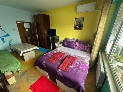 a bedroom with a purple bed with two red pillows at Sleep & fly in Sofia