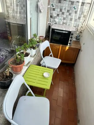 a small balcony with a green table and chairs at Sleep & fly in Sofia