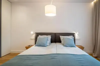 a bedroom with a large bed with blue pillows at Top-Notch location, an Exceptionally Stylish flat in Sofia