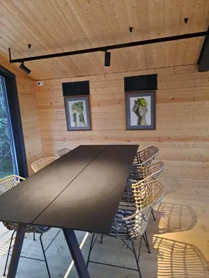 a table and chairs in a room with wooden walls at Saint Constantine Mountain Retreat in Peshtera