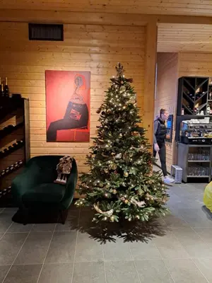 a christmas tree in a room with a green chair at Saint Constantine Mountain Retreat in Peshtera