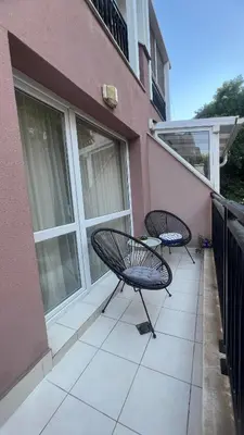 two chairs and a table on the balcony of a building at Soflu apartments Plovdiv in Plovdiv