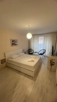 a bedroom with a large white bed and a table at Soflu apartments Plovdiv in Plovdiv
