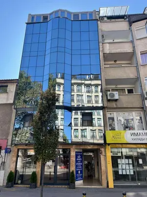 a tall building with mirrored windows on a city street at Cityscape Luxury Suites in Plovdiv