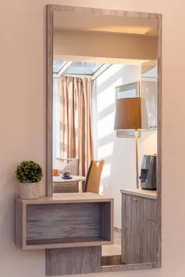 a mirror on a wall with a desk and a lamp at Cityscape Luxury Suites in Plovdiv