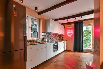 a kitchen with white cabinets and a red wall at Lozenetz Gem Cozy 1-Bedroom Apartment in Sofia by Flat Mаnager in Sofia