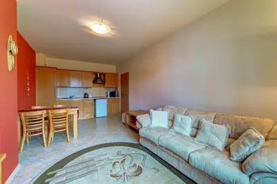 a living room with a couch and a kitchen at Panorama Studio in Stoykite