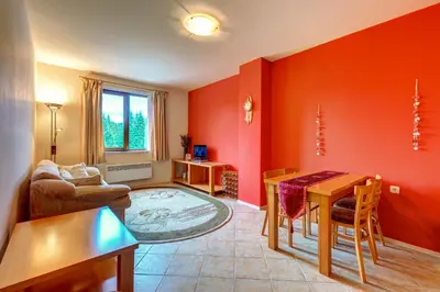 a living room with red walls and a table and chairs at Panorama Studio in Stoykite