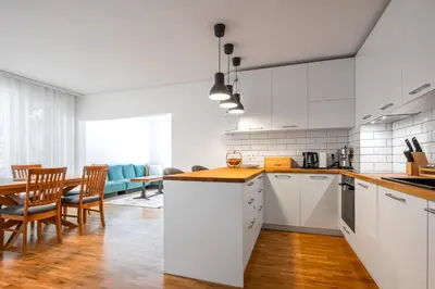 a kitchen with white cabinets and a table and chairs at Contemporary Comfort 1BD Flat in Lozenetz, Sofia by Flat Mаnager in Sofia