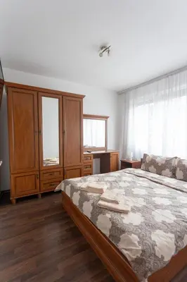 a bedroom with a large bed and wooden furniture at Karastoyanovi's apartment 3 in Sofia