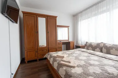 a bedroom with a bed and a cabinet and a television at Karastoyanovi's apartment 3 in Sofia