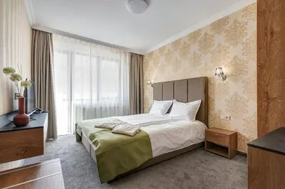 a bedroom with a bed and a large window at Къща за гости Чудните Мостове in Zabŭrdo