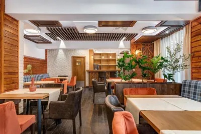 a restaurant with wooden walls and tables and chairs at Къща за гости Чудните Мостове in Zabŭrdo