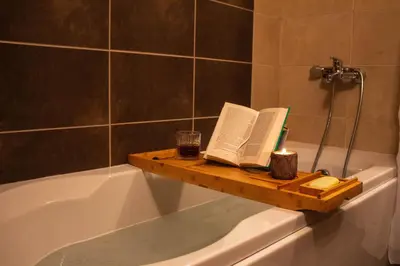 a bathroom with a bath tub with a book and candles at Aspen Valley Sun Rays A102 in Razlog