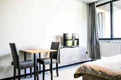 a room with a table and two chairs and a bed at 6 Studios 6 Bathrooms 2 Levels Kitchens in Sofia