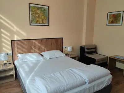 a bedroom with a large bed and a chair at стаи за гости TODA in Troyan