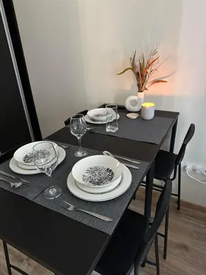 a black table with plates and wine glasses on it at Cozy Riverside Pine Studio E5 in Borovets