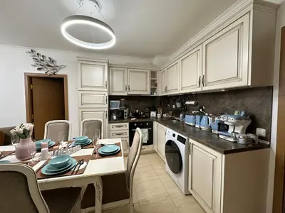 a kitchen with white cabinets and a table with blue dishes at Vintage De Lux, Top Location, 2Bdr Grand Monastery, Pamporovo in Pamporovo