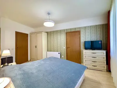 a bedroom with a blue bed and a television at Vintage De Lux, Top Location, 2Bdr Grand Monastery, Pamporovo in Pamporovo