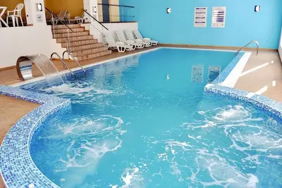 a large swimming pool with blue water in a building at Forest view in Pamporovo