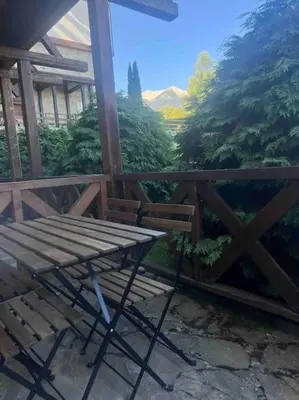a wooden table and bench on a balcony with a view at Cosy Appartement Green Life Bansko in Bansko