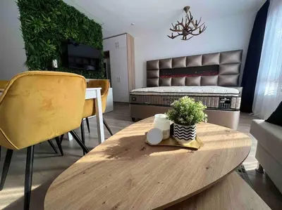 a living room with a table and a bed at Cosy Appartement Green Life Bansko in Bansko