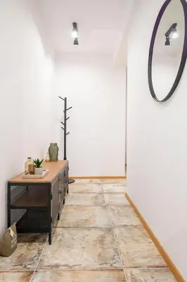 a room with a table and a mirror on the wall at Three Lilies Apartments in Plovdiv