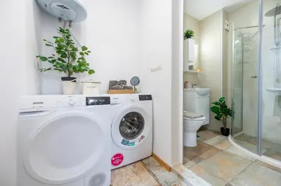 a washing machine in a bathroom with a toilet at Three Lilies Apartments in Plovdiv