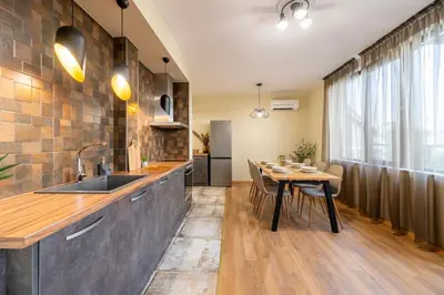 a kitchen with a table and a sink and a counter at Three Lilies Apartments in Plovdiv