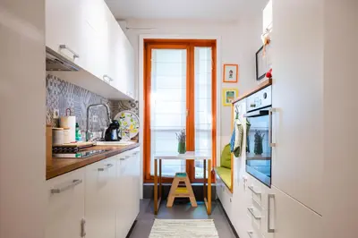 a kitchen with white cabinets and a table in it at Colorful Getaway right next to NDK by Flat Mаnager in Sofia