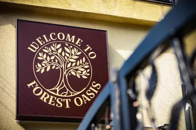 a sign for a hotel on the side of a building at Forest Oasis Guest House FREE PARKING in Sapareva Banya