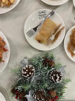 a table topped with plates of food with a piece of cake at Hotel Panorama Ski in Pamporovo