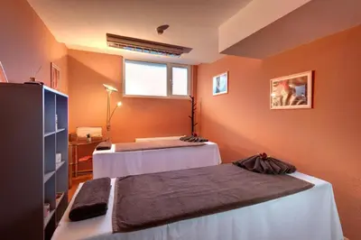 two beds in a room with orange walls at Hotel Panorama Ski in Pamporovo