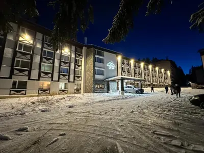 a building with lights in the snow at night at Hotel Panorama Ski in Pamporovo
